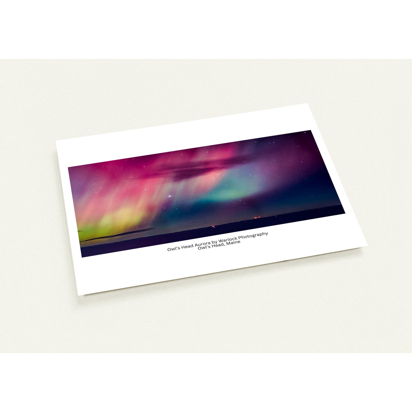A 10-pack of 'Owl's Head Aurora' postcards by Warlock Photography, featuring a wide-angle photograph of the Aurora Borealis over Owl's Head, Maine.