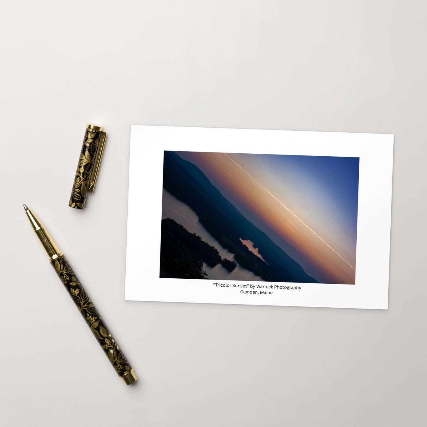 A captivating landscape of Camden, Maine at dusk. This premium art postcard features a rich tricolor gradient of twilight blues, warm oranges, and soft pinks. Printed on thick, high-quality matte paper.